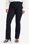 Bootcut jeans in donkerblauw denim van Levi's, gedragen met een wit overhemd en zwarte sandalen.