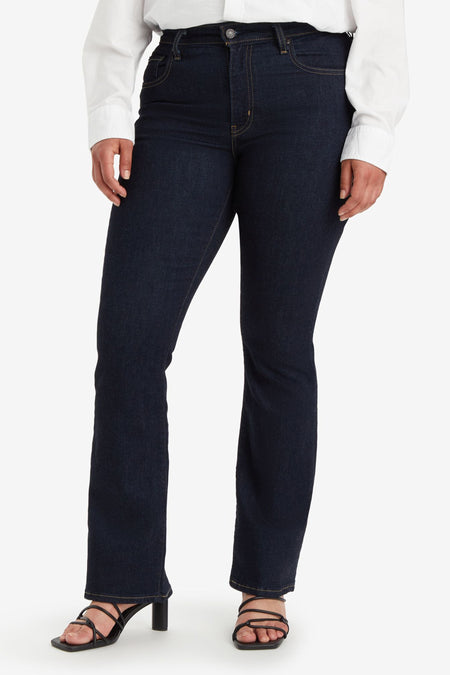 Jean bootcut bleu foncé de Levi's®, porté avec une chemise blanche et des talons noirs.