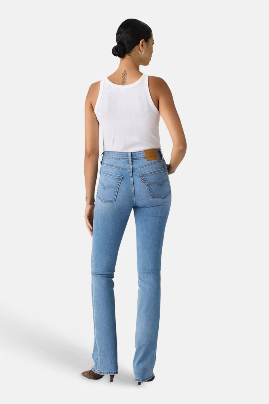 Mid blue bootcut jeans by 725, back view, classic five-pocket design with brown leather waistband patch, worn with white tank top and heels