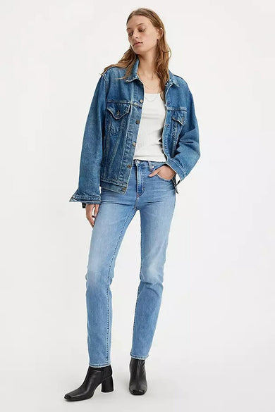Jean droit bleu moyen de Levi's, porté avec une veste en jean et des bottines noires.