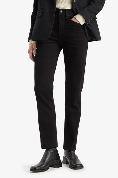 Jean droit en denim noir de Levi's, porté avec un blazer noir et des bottines en cuir.