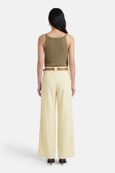 Gele Terra di Siena broek, met een bruine riem, wijde pijpen, gedragen met naaldhakken.