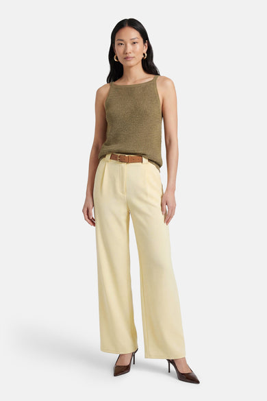 Gele Terra di Siena broek, rechte pasvorm, gedragen met een olijfgroene top en een bruine riem.