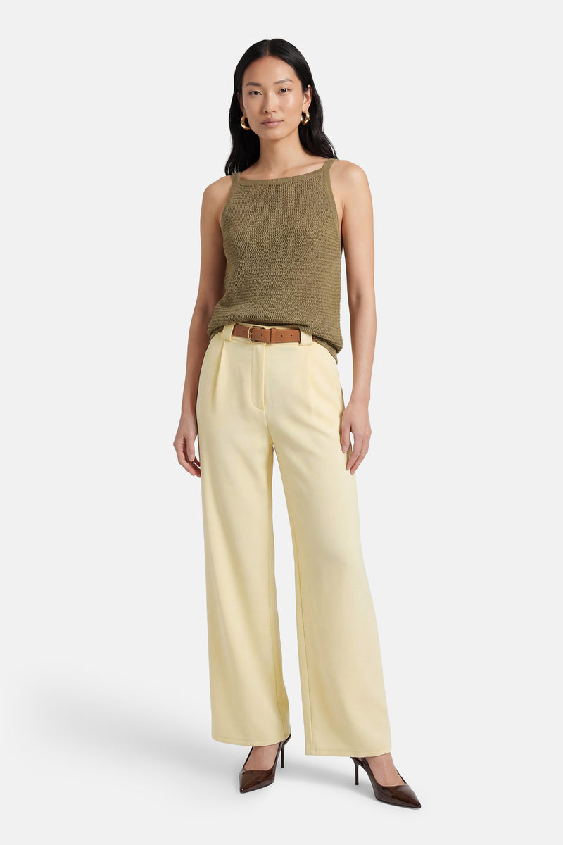 Gele Terra di Siena broek, rechte pasvorm, gedragen met een olijfgroene top en een bruine riem.