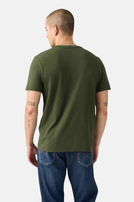 Groen T-shirt met korte mouwen van Levi's®, van achteren gezien, gedragen met een blauwe spijkerbroek.