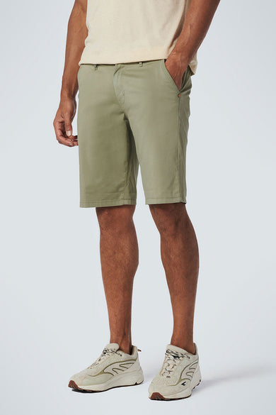 Short vert par NO EXCESS, porté avec un t-shirt beige et des chaussures de sport beiges, en vue latérale.
