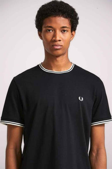 T-shirt noir à manches courtes de FRED PERRY, avec bordures blanches au col et aux manches, logo brodé sur la poitrine.

