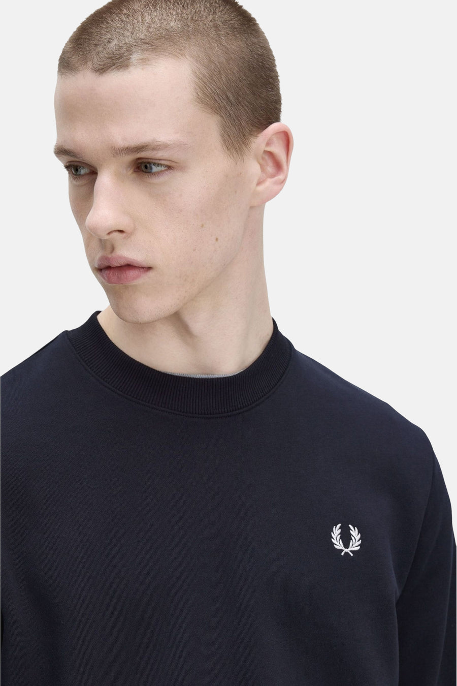 Blauwe sweater van Fred Perry met een toon-op-toon geborduurd logo op de borst.