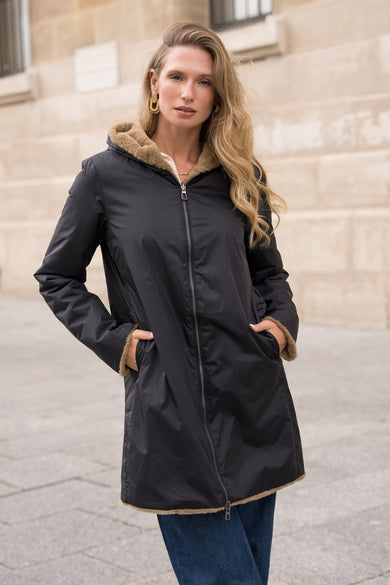 Imperméable noir de Laura Jo avec doublure effet fourrure, porté avec un jean bleu.

