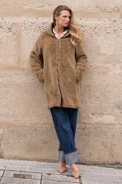 Imperméable noir de LAURA JO avec fermeture éclair, porté avec un pantalon bleu retroussé et des chaussures nude.