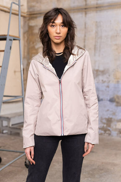 Beige regenjas van LAURA JO, van achteren gezien, met een capuchon en gedragen met een zwarte jeans.