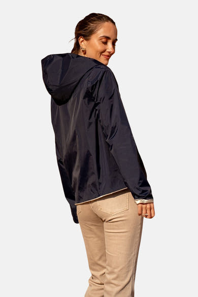 Blauwe regenjas van LAURA JO, met een capuchon, gedragen met een beige spijkerbroek.