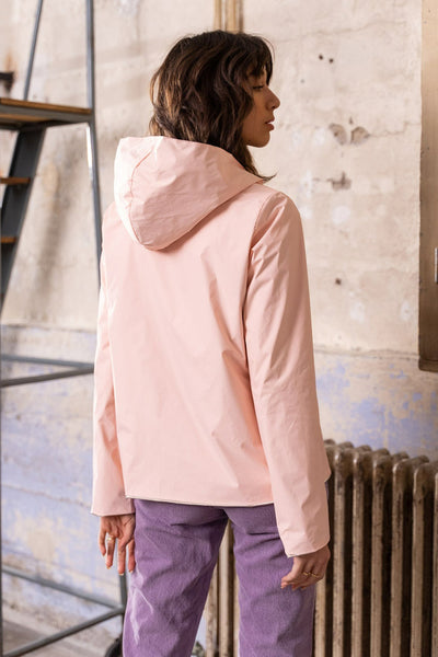 Veste de pluie rose de LAURA JO, vue de dos avec capuche, portée avec un pantalon lilas.
