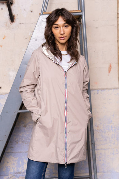 Beige regenjas van LAURA JO, met driekleurige ritssluiting, zilveren capuchon en zakken.