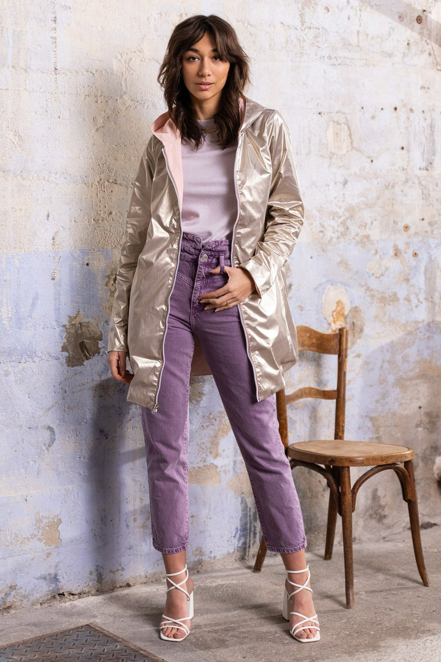 Roze regenjas van LAURA JO met capuchon, gedragen met een paarse broek en witte sandalen met hak.