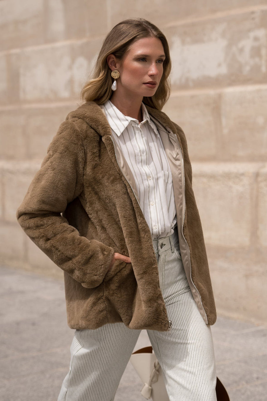 Beige regenjas van LAURA JO van imitatiebont gedragen over een gestreept overhemd en een gestreepte broek.
