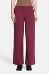 Burgundy wide-leg pants with elastic waistband, front pleats, and straight fit, worn with black loafers, front view