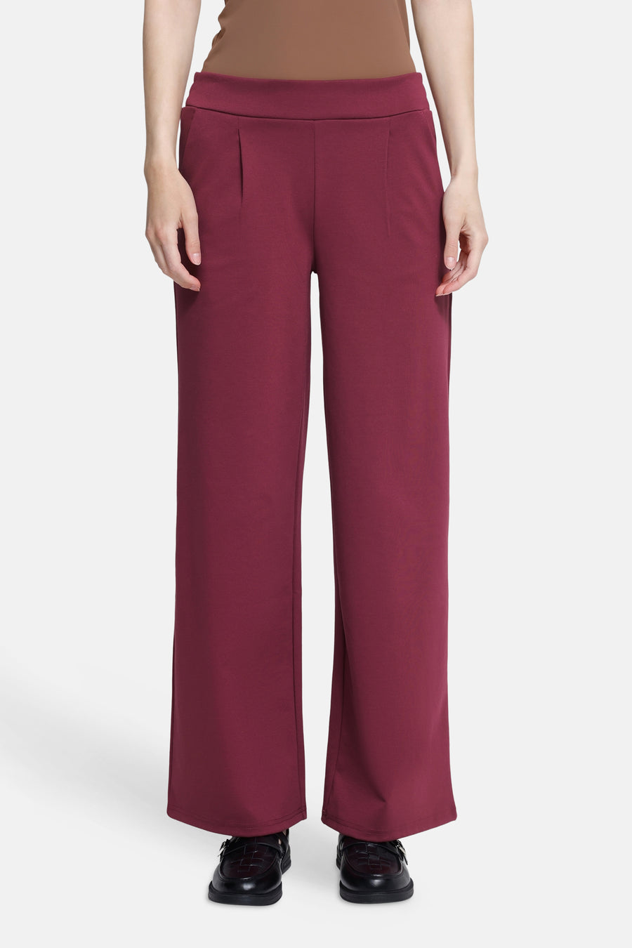 Burgundy wide-leg pants with elastic waistband, front pleats, and straight fit, worn with black loafers, front view