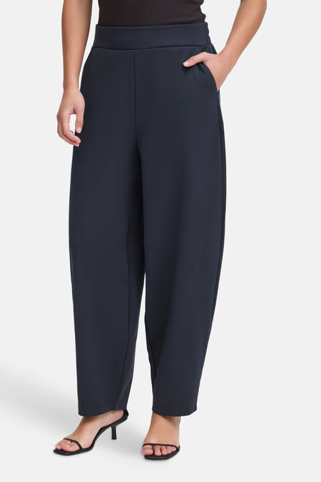 Navy blue wide-leg trousers by ICHI, featuring a high elastic waistband and sleek straight fit, shown on model with black heels.