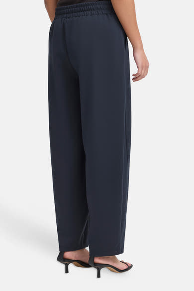 Navy blue wide-leg trousers with elastic waistband by ICHI, shown from back view on model wearing black heels