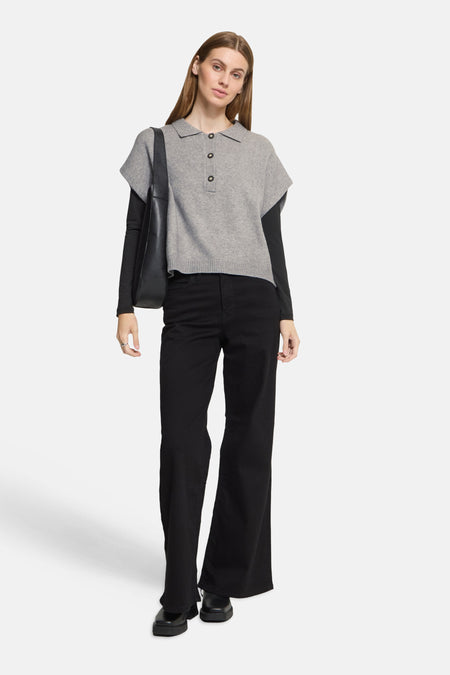 Grey knit sleeveless top with button placket by ICHI, worn over black long-sleeve shirt, paired with black wide-leg pants and chunky boots, full-length front view.
