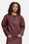 Burgundy faux leather vest by ICHI, featuring wide lapels, front buttons, and waist belt, worn with striped top, front view.