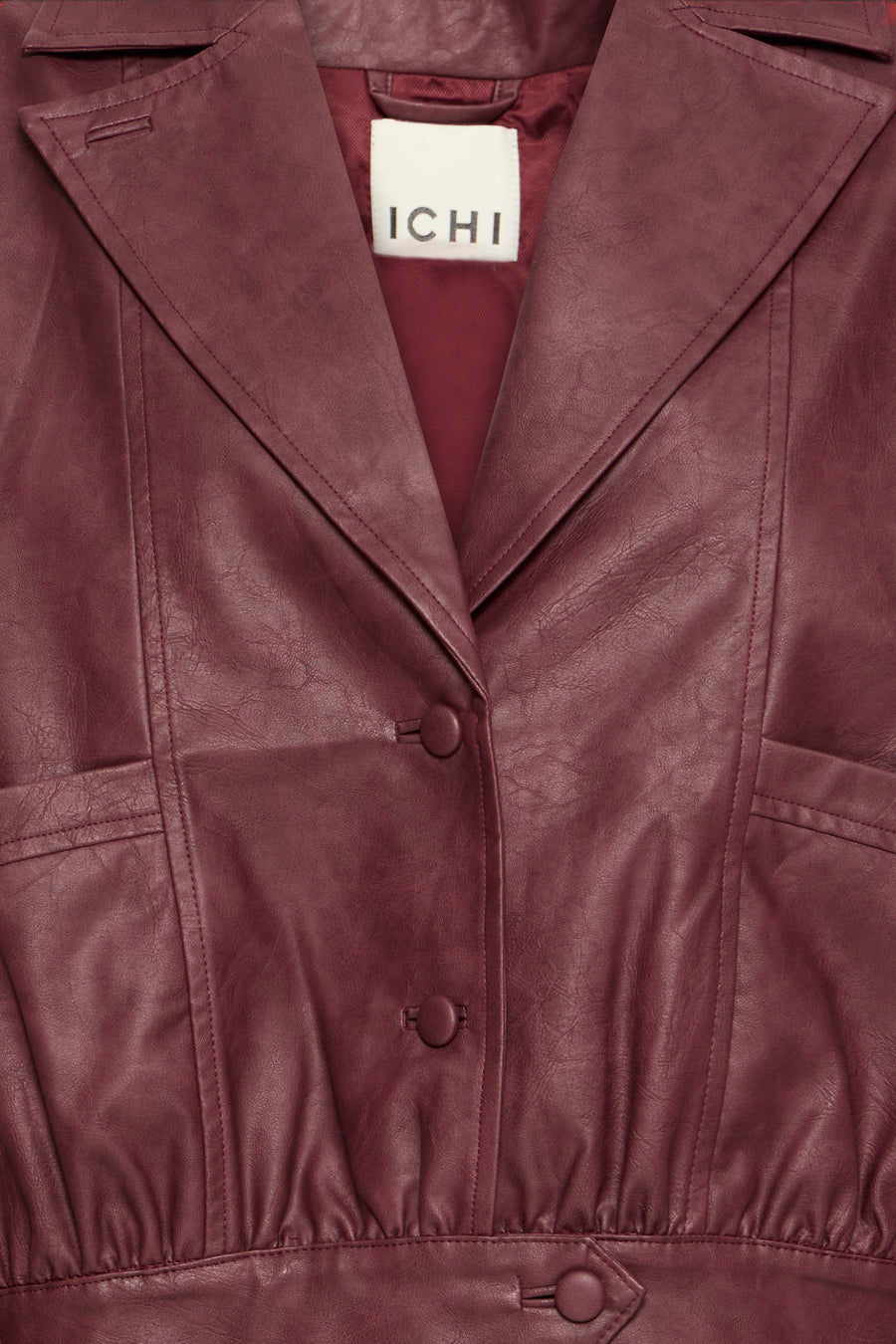 Burgundy faux leather vest by ICHI with structured lapels, button closure, and textured surface in close-up front view