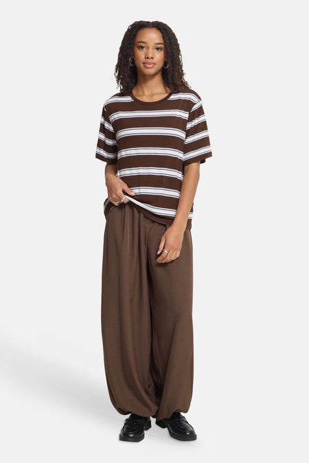 Brown and white striped short-sleeve T-shirt with ribbed texture, worn with matching wide-leg pants and black loafers, front view.