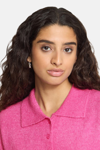 Rose pink knitted gilet with collar and button front, cropped front view on model