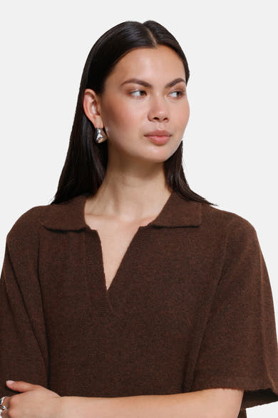 Brown short-sleeve knit robe with V-neck and collar, worn by model in side view, textured fabric, silver earrings visible