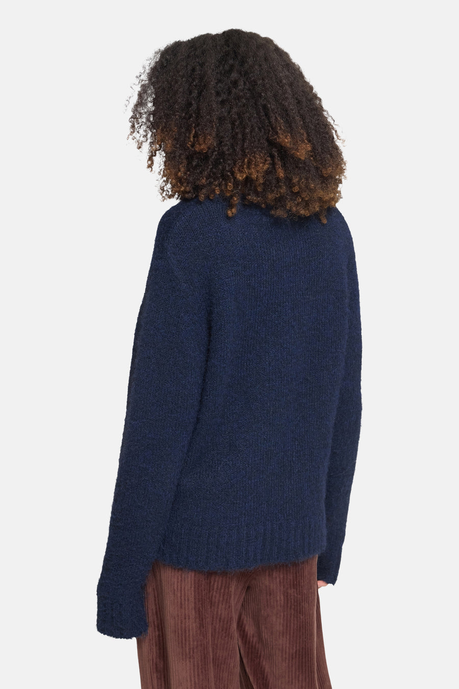 Navy blue O-neck sweater with textured knit, shown from back on model wearing brown corduroy pants