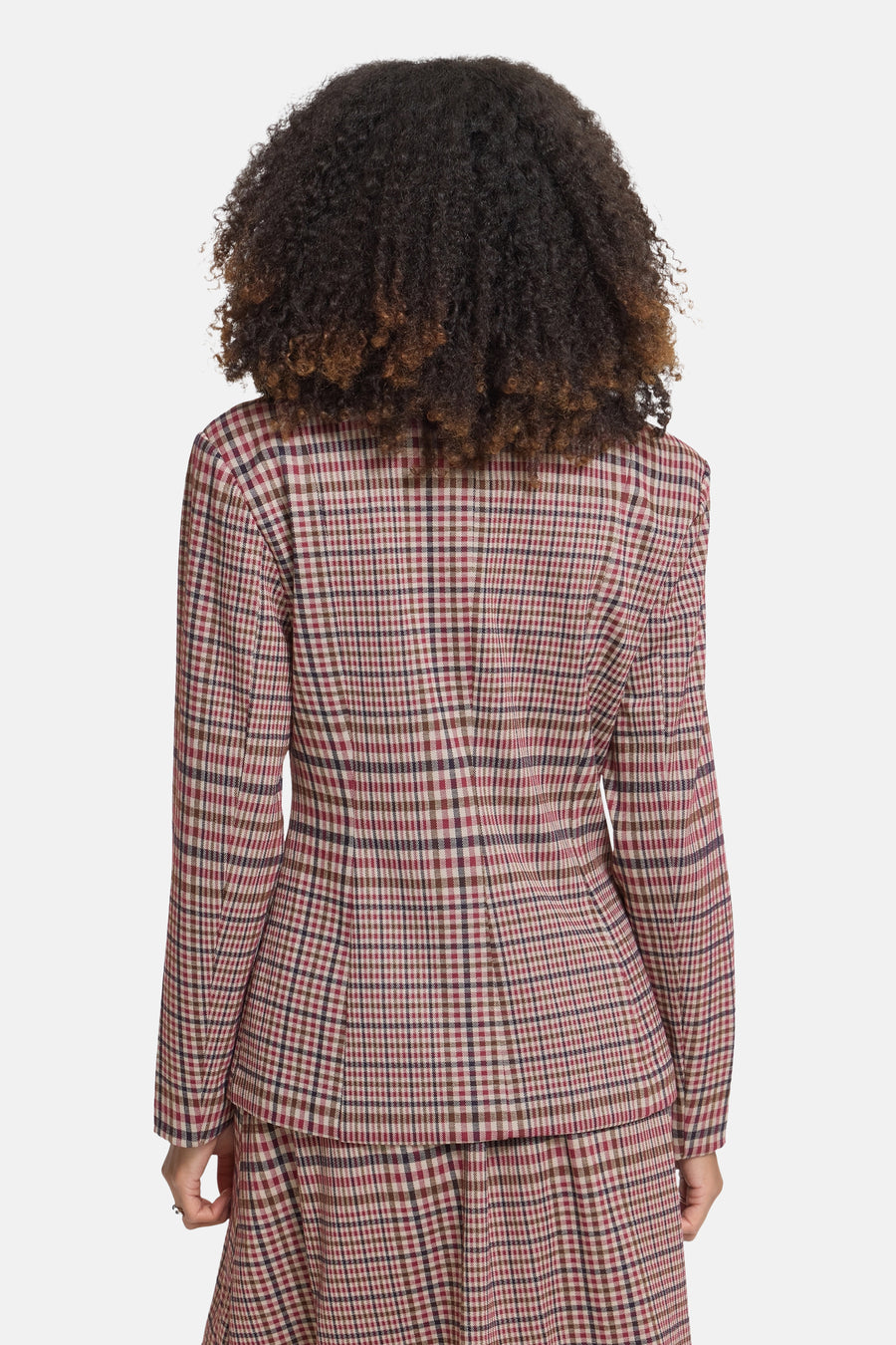 Multicolored plaid blazer back view featuring red, beige, and brown check pattern with structured shoulders and tailored fit on model with curly hair