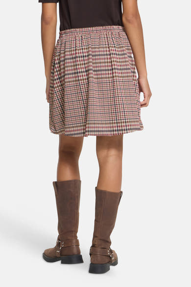 Multicolored plaid mini skirt with elastic waist, back view, worn with brown boots and dark top