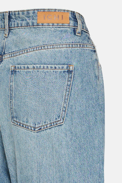 Mid blue denim jeans by ICHI, back view with faded wash, brown stitching, and leather brand patch above rear pocket