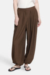 Brown wide-leg elastic waist trousers with pleated front and gathered ankles, worn with white top and black flip-flops, front view