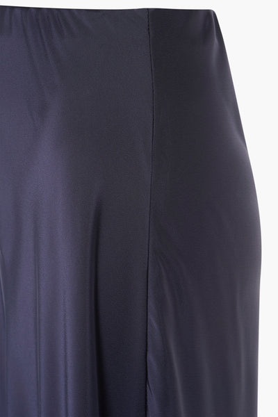 Navy blue midi skirt with smooth fabric and central seam, side view close-up