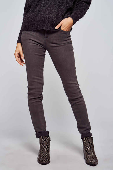 Jean skinny gris de Morgan de Toi, porté avec un pull foncé texturé et des bottines imprimées serpent.
