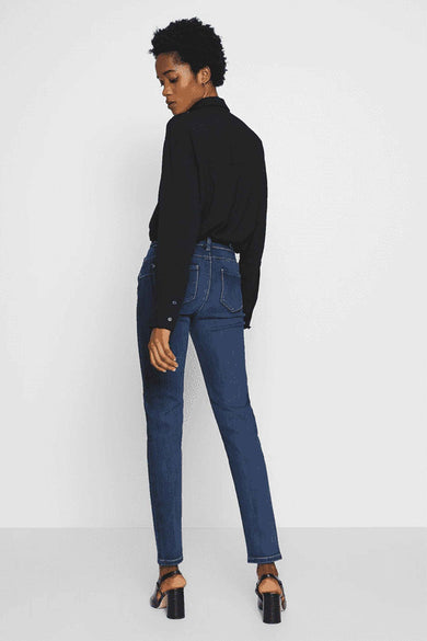 Jean skinny bleu de Morgan de Toi, porté avec un chemisier noir et des talons hauts noirs.