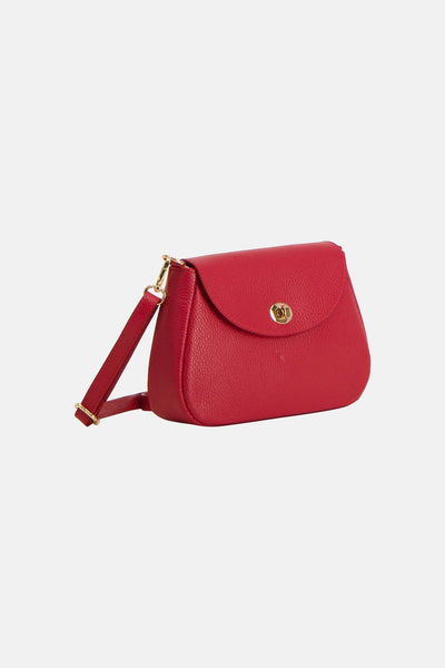 Sac à bandoulière rouge en cuir par Access®, avec une bandoulière réglable dorée et une fermeture à bouton pivotant.