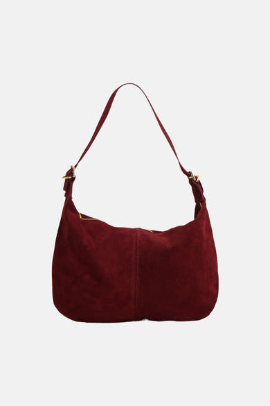 Red suede shoulder bag with gold-tone hardware, front view, soft texture, curved silhouette