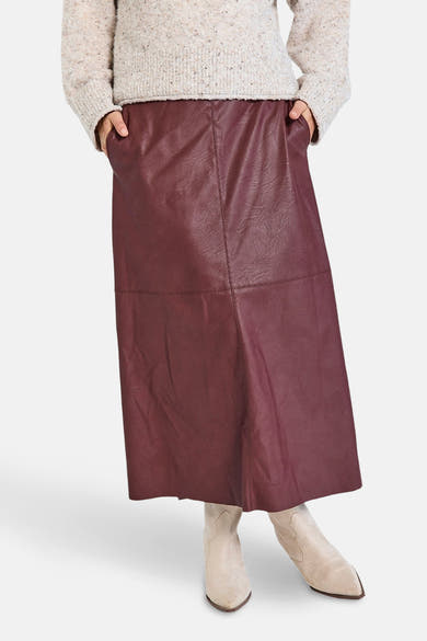 Lange bordeaux rok van FREEQUENT, leren stijl met zakken, gedragen met een gemêleerde gebreide trui en lichte enkellaarsjes.