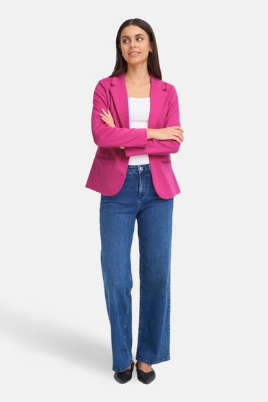 Blazer rose de Fransa, porté avec un débardeur blanc et un jean bleu ample.
