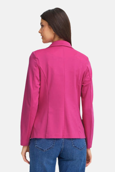 Blazer rose de Fransa, avec une coupe ajustée et porté avec un jean bleu.
