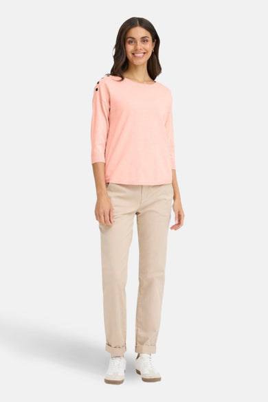 Pull rose à col rond de Fransa, avec des boutons décoratifs sur l'épaule et porté avec un pantalon beige.
