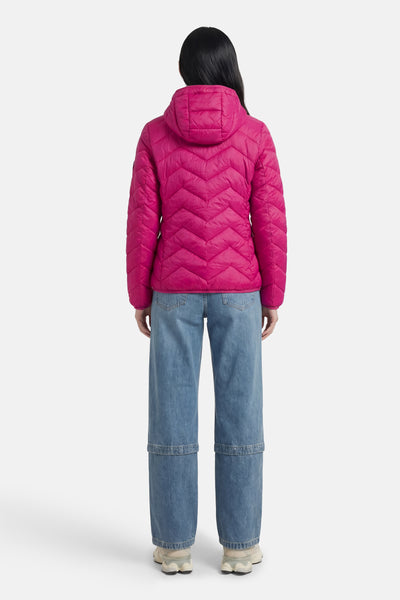Veste courte rose de Fransa, à motif matelassé en chevrons, portée avec un jean ample.
