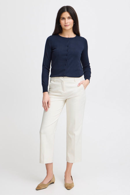 Chino bleu de Fransa, porté avec un cardigan bleu marine boutonné et des chaussures plates en daim.