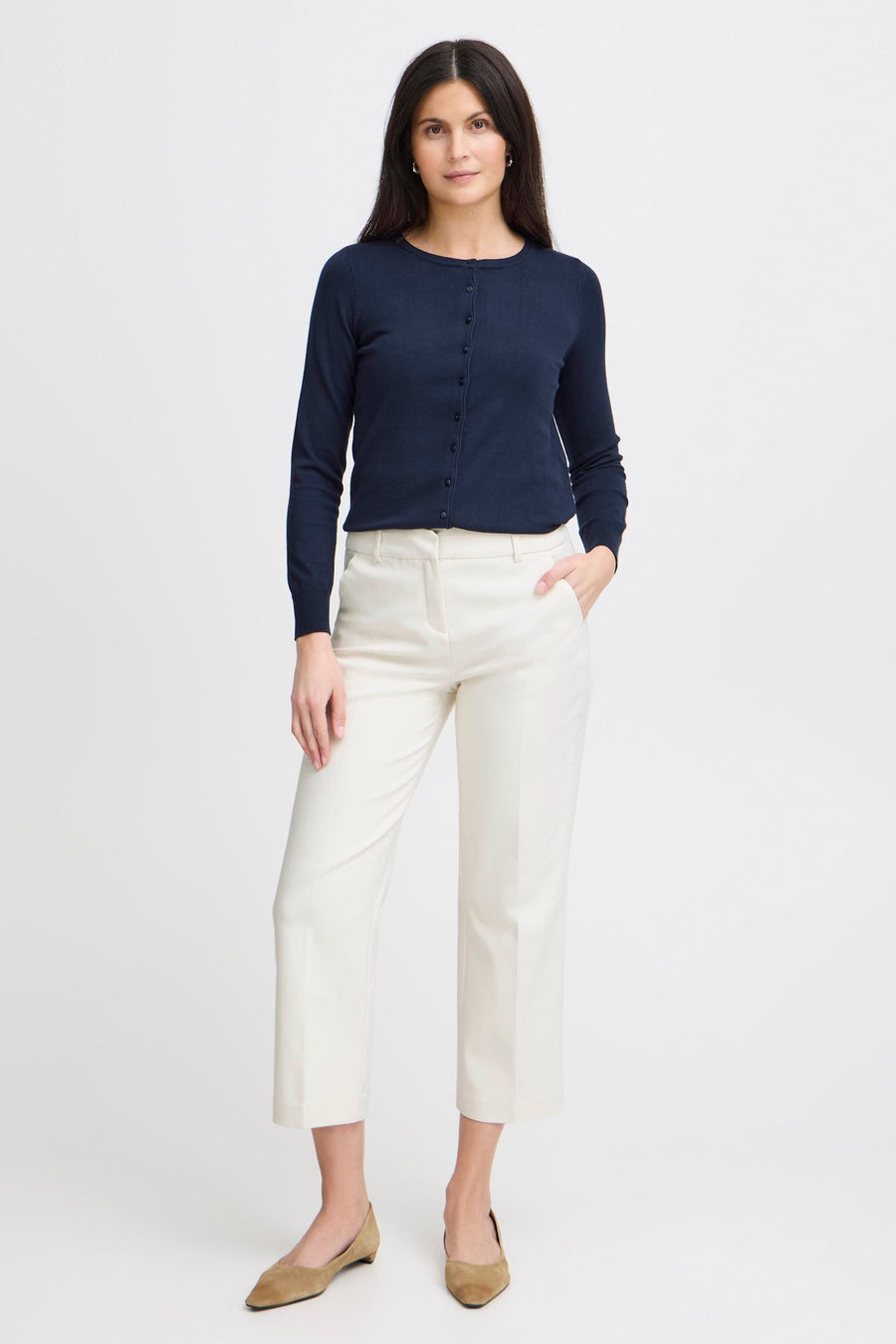 Chino bleu de Fransa, porté avec un cardigan bleu marine boutonné et des chaussures plates en daim.