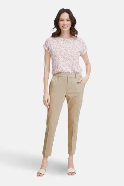 Chino beige de Fransa, porté avec un chemisier à fleurs et des chaussures ouvertes.