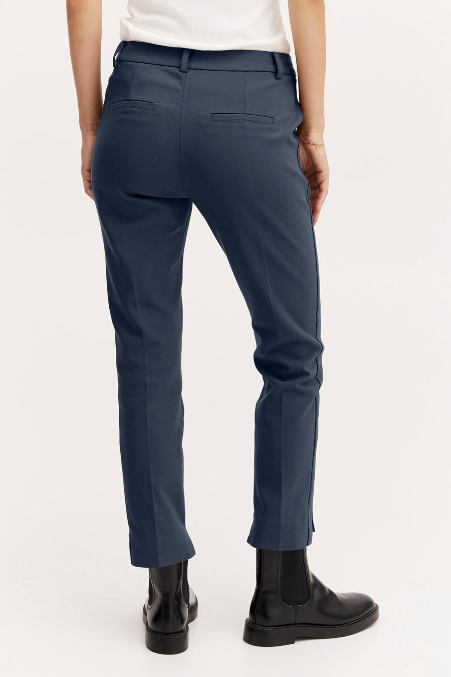 Pantalon chino beige de Fransa, avec des détails de style, porté avec des bottes noires.