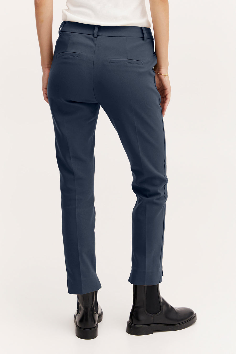 Chino bleu marine de Fransa, avec des poches arrières et porté avec des bottes noires.
